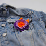 Елегантна брошка цвете в артистично светло, тъмно лилаво и ярко оранжево