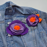 Елегантна брошка цвете в артистично светло, тъмно лилаво и ярко оранжево