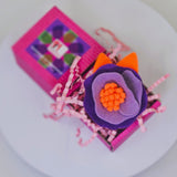 Елегантна брошка цвете в артистично светло, тъмно лилаво и ярко оранжево